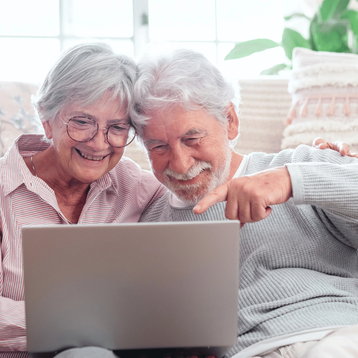 Pareja de adultos mayores mirando información en su computadora
